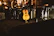 A close-up of a guitar and a microphone stand bathed in warm stage light at a small venue.