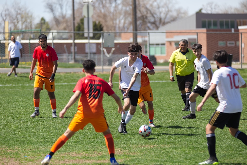 group of men playing soccer during daytime