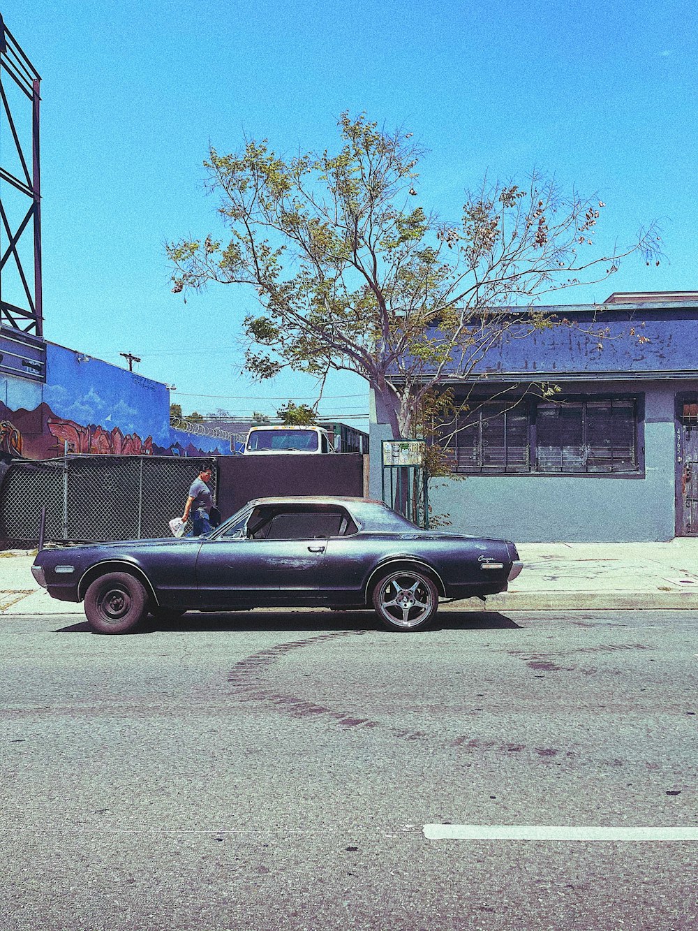 black coupe parked beside blue and white building during daytime