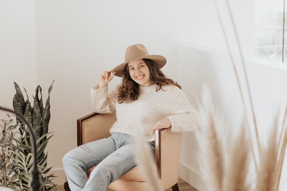 Donna in camicia bianca a maniche lunghe e pantaloni grigi seduta sul sedile di legno marrone