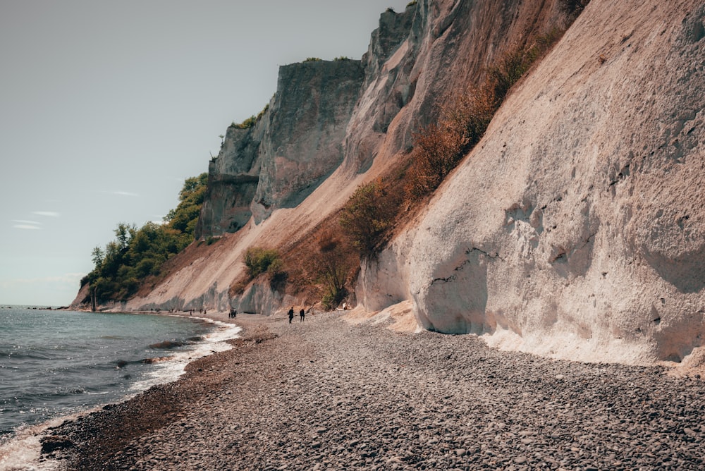 brown rocky mountain near body of water during daytime