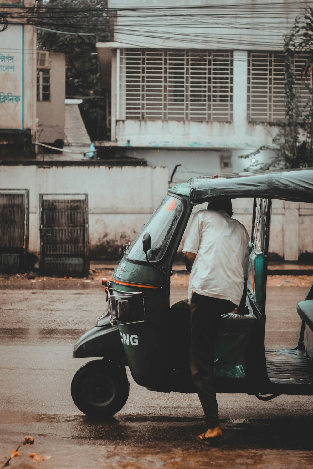 man in white shirt and black pants standing beside black motorcycle during daytime