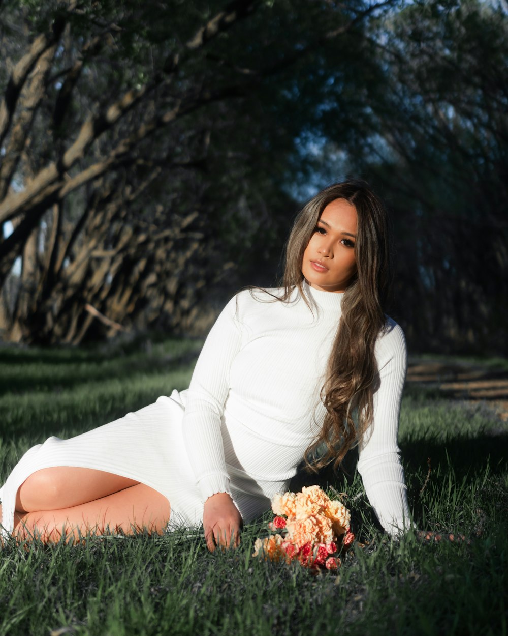 woman in white long sleeve shirt sitting on green grass field