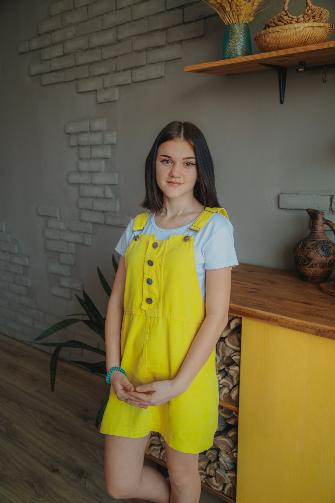 girl in blue and yellow school uniform standing near brown wooden table