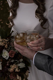 woman in white blazer holding clear drinking glass