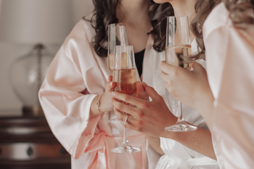 woman in white long sleeve shirt holding clear drinking glass