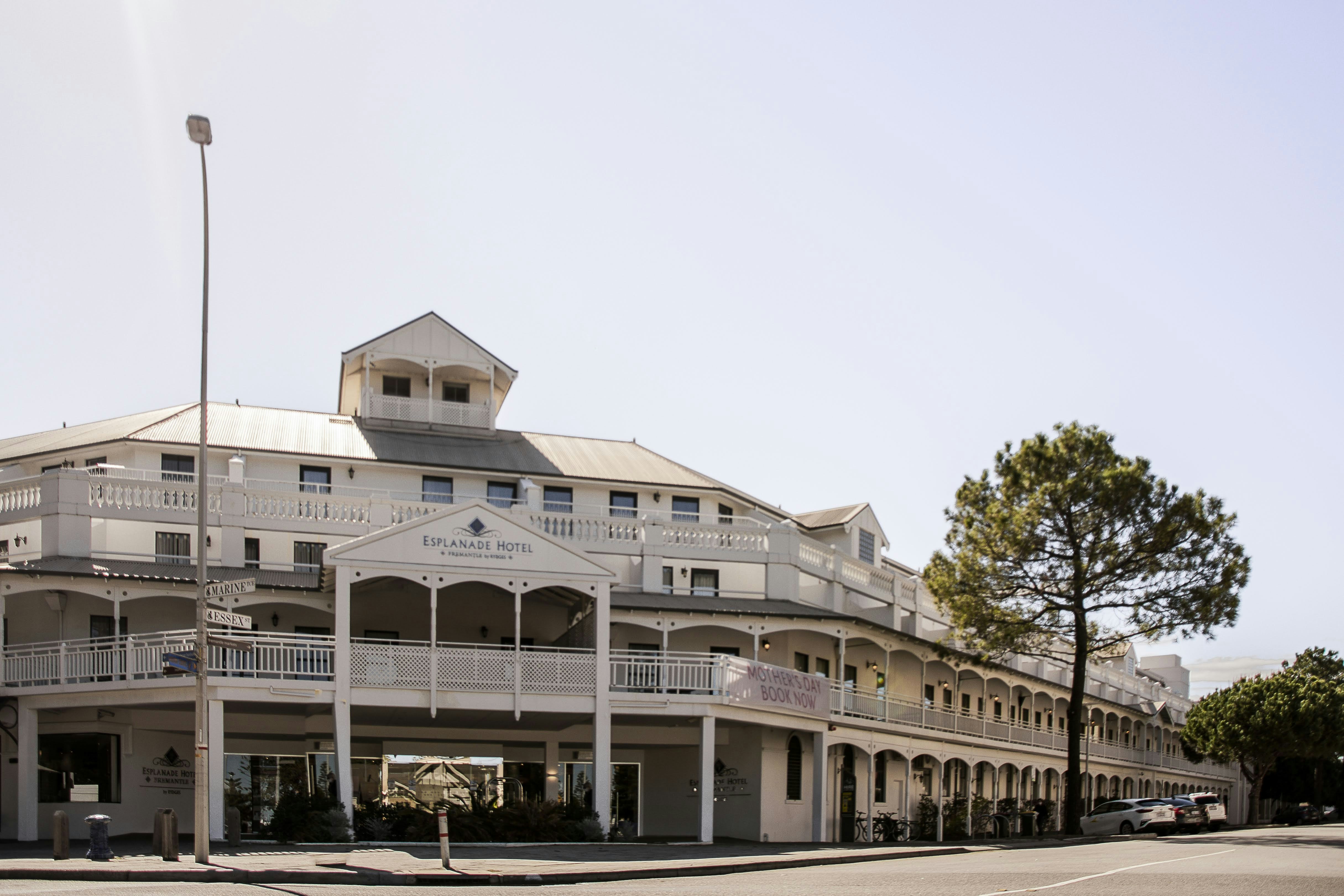 white concrete building near green trees during daytime, 