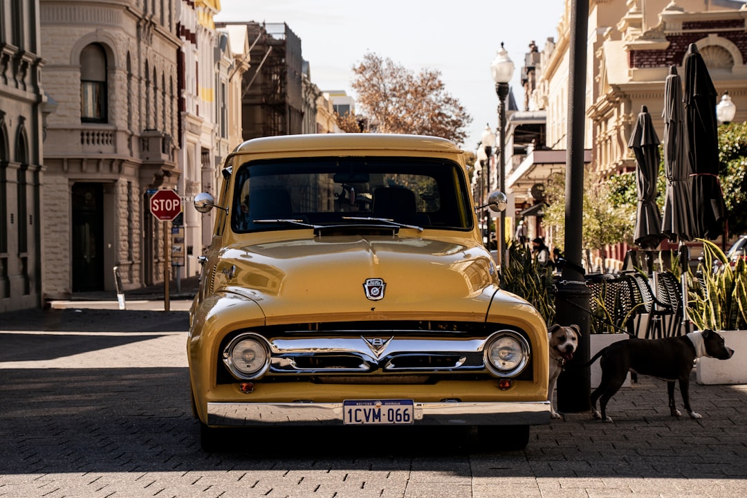 yellow car parked on sidewalk during daytime