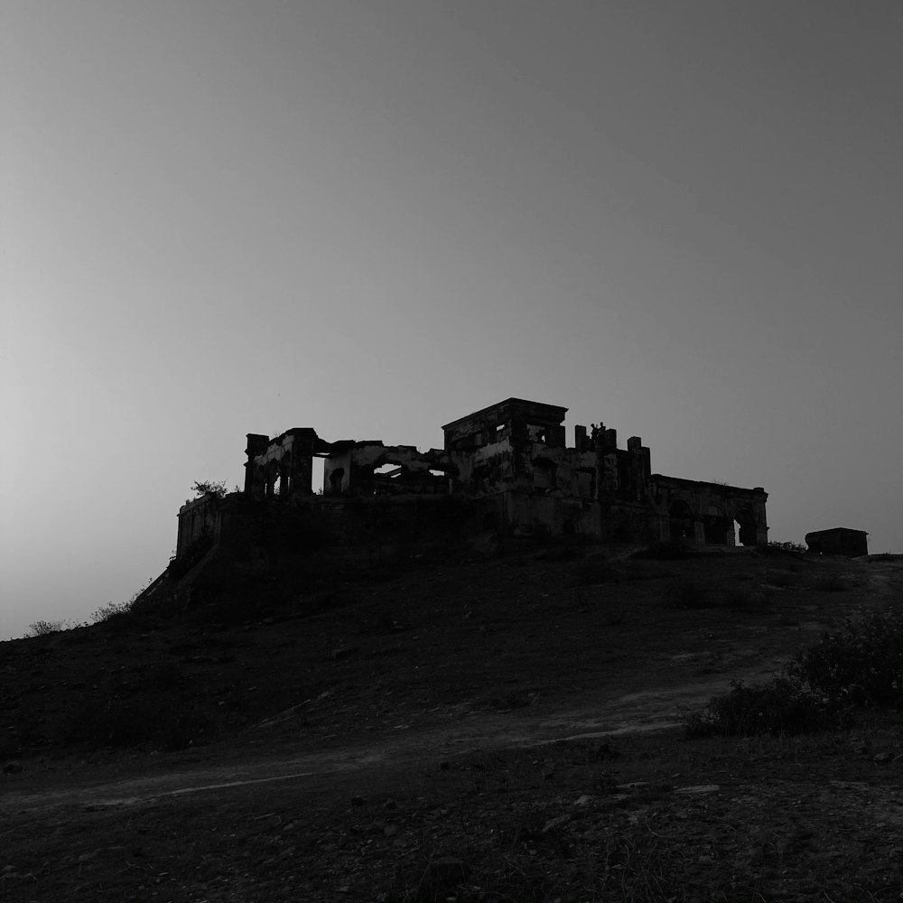 grayscale photo of building on hill