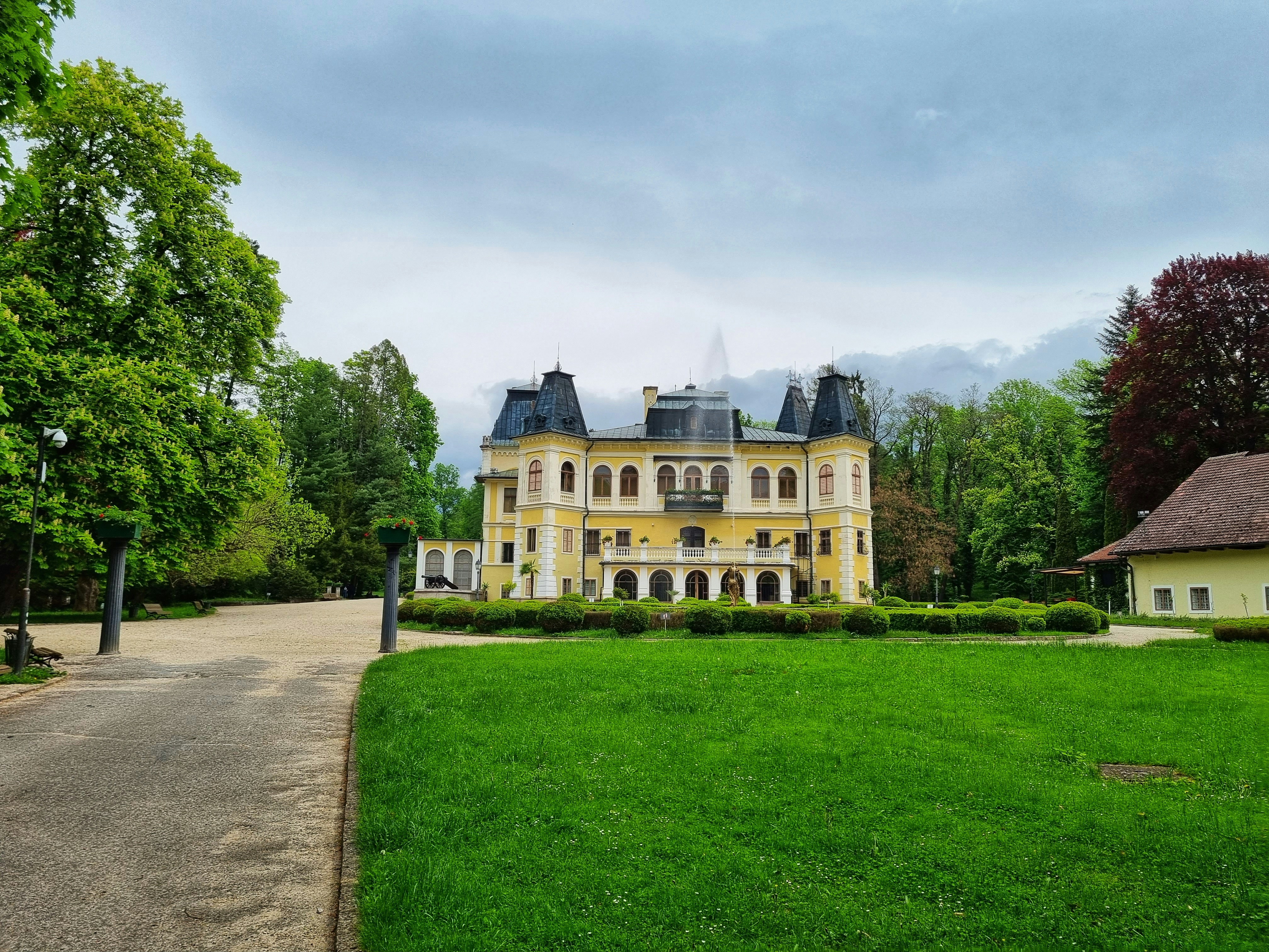 green grass field near white concrete building under white clouds during daytime, Betliar Manor House