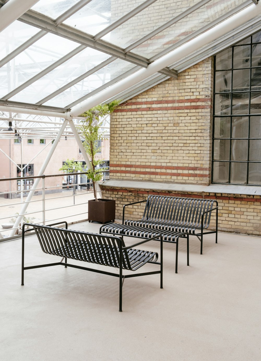 black metal bench near brown brick wall