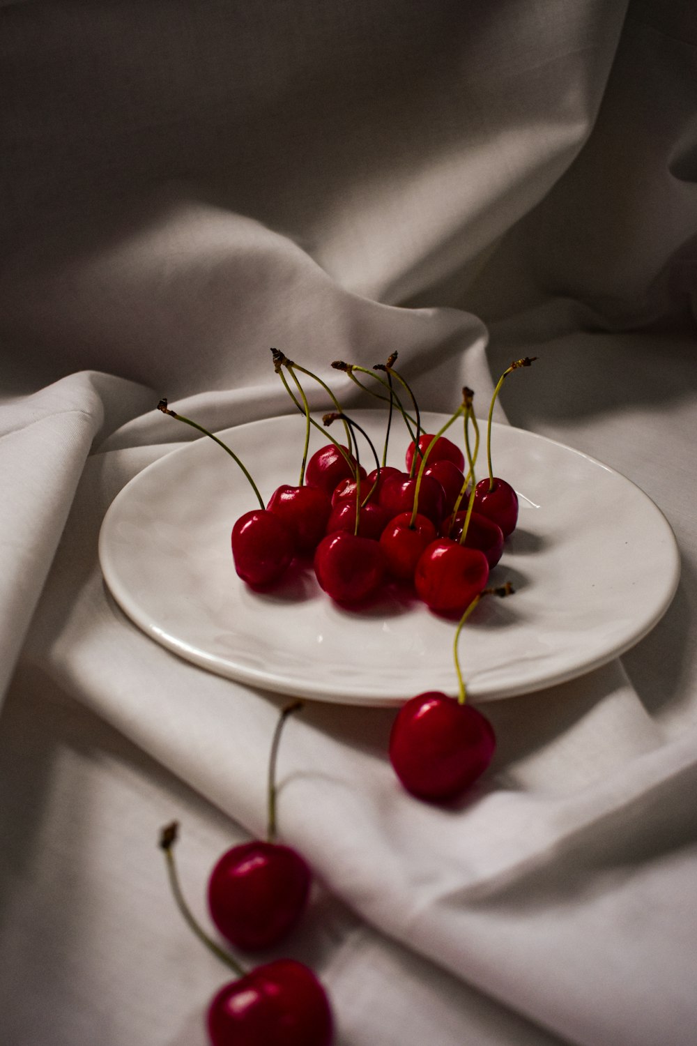 red cherries on white ceramic plate