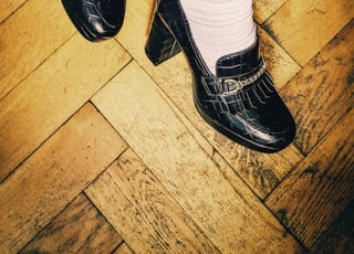 person wearing black leather shoes