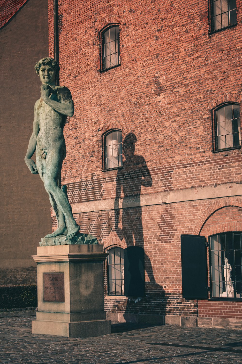 man riding horse statue near brown brick building during daytime