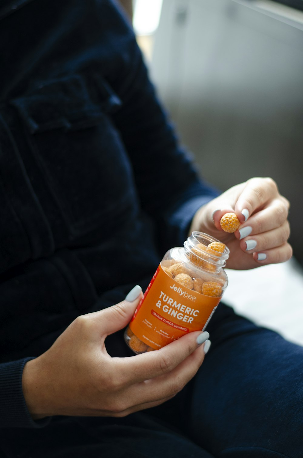 person holding orange plastic bottle