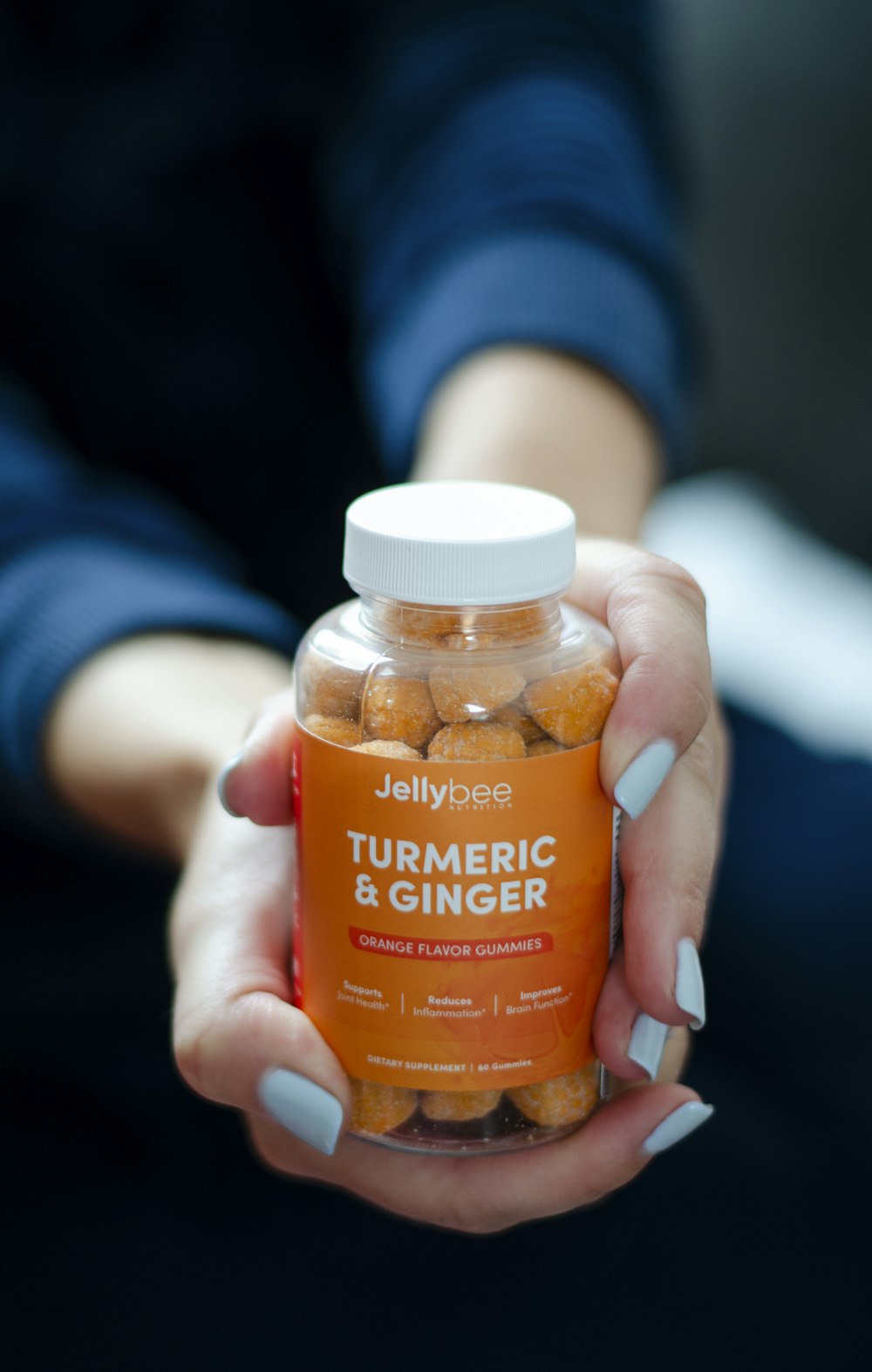 a person holding a jar of turm epic and ginger