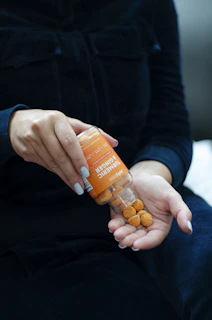 person holding orange plastic bottle