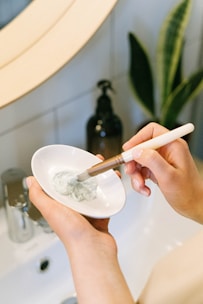 person holding white ceramic bowl with silver spoon