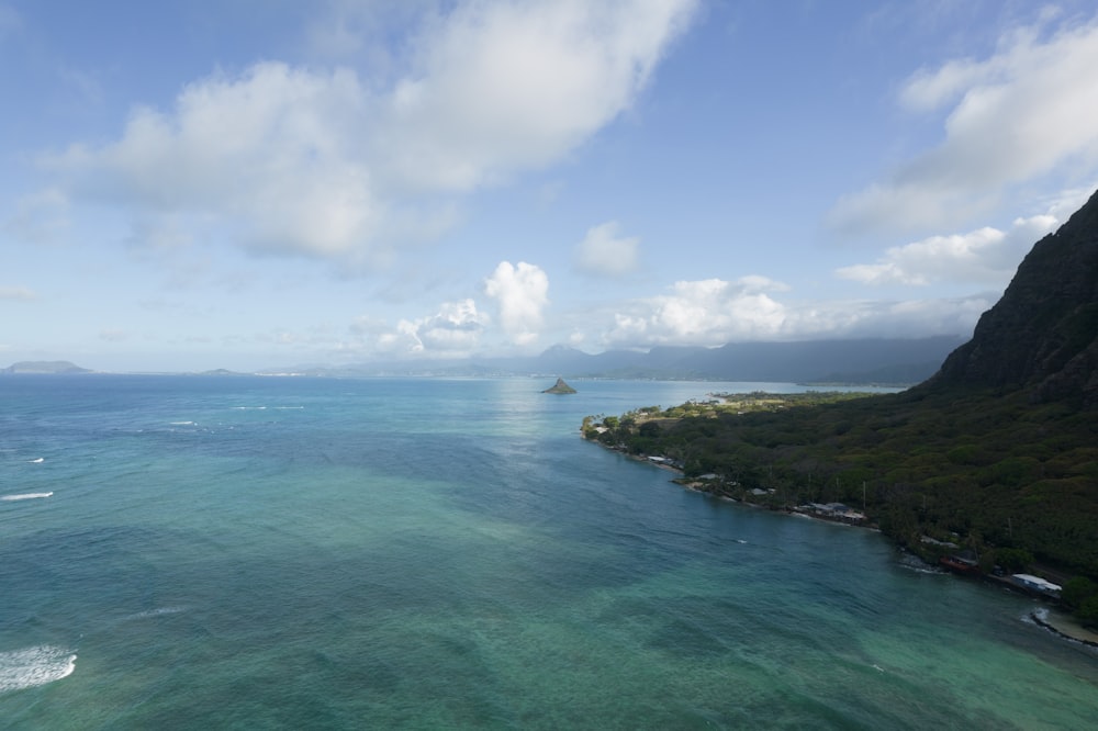 green and brown island under blue sky and white clouds during daytime