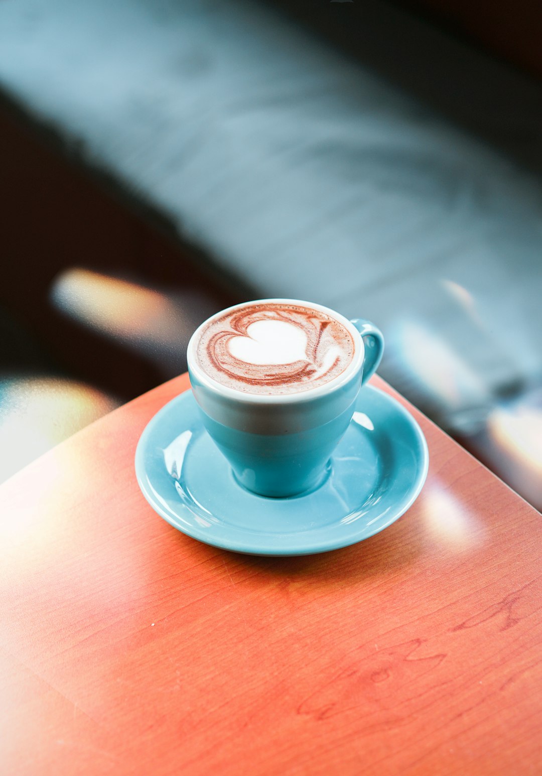 blue ceramic cup with saucer on brown wooden table