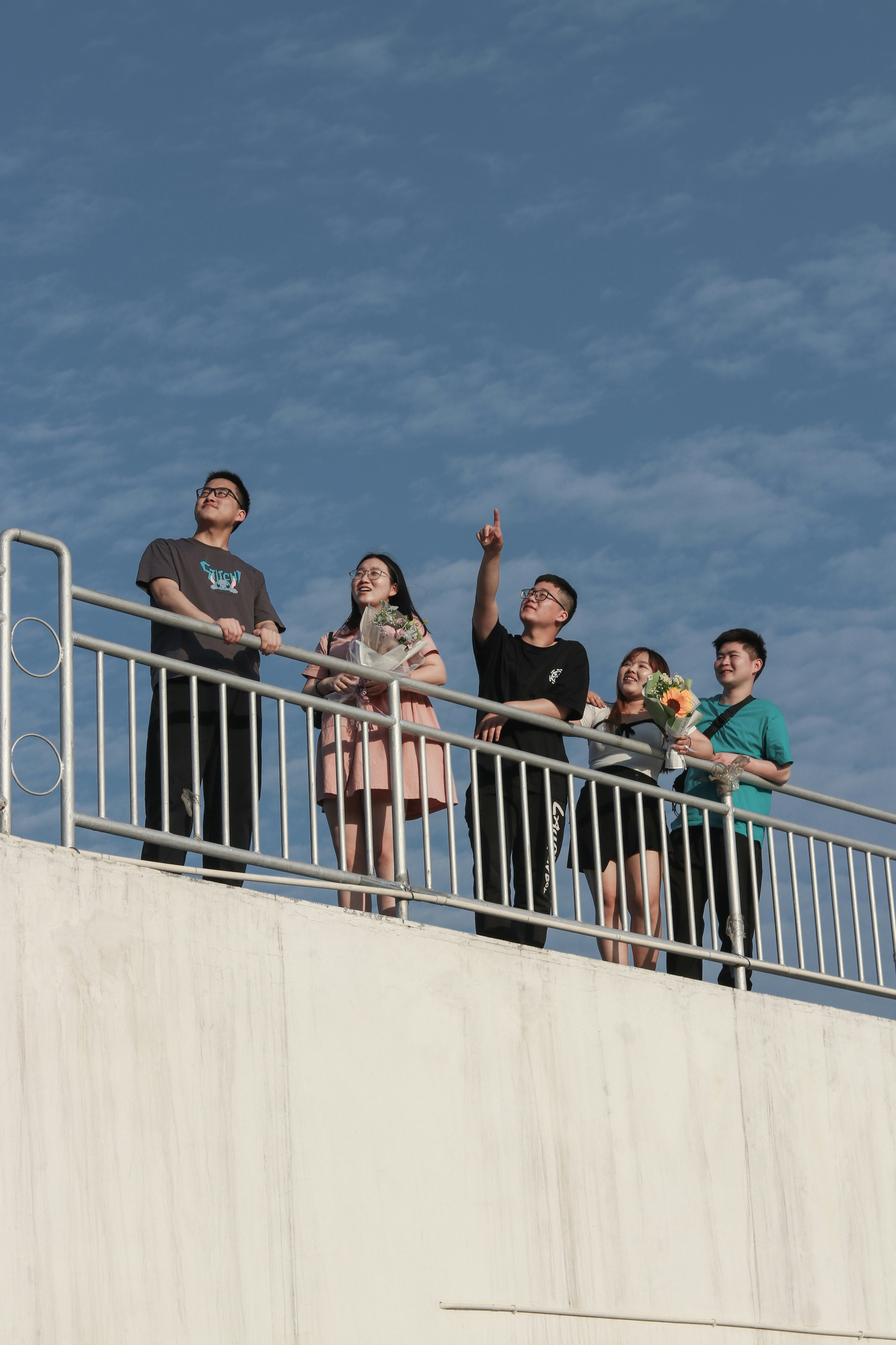 group of people standing on white concrete wall during daytime