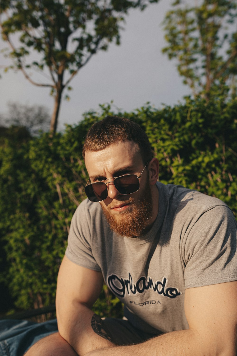 man in gray crew neck t-shirt wearing black sunglasses