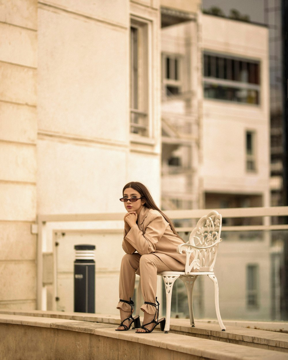 woman in brown coat sitting on white chair