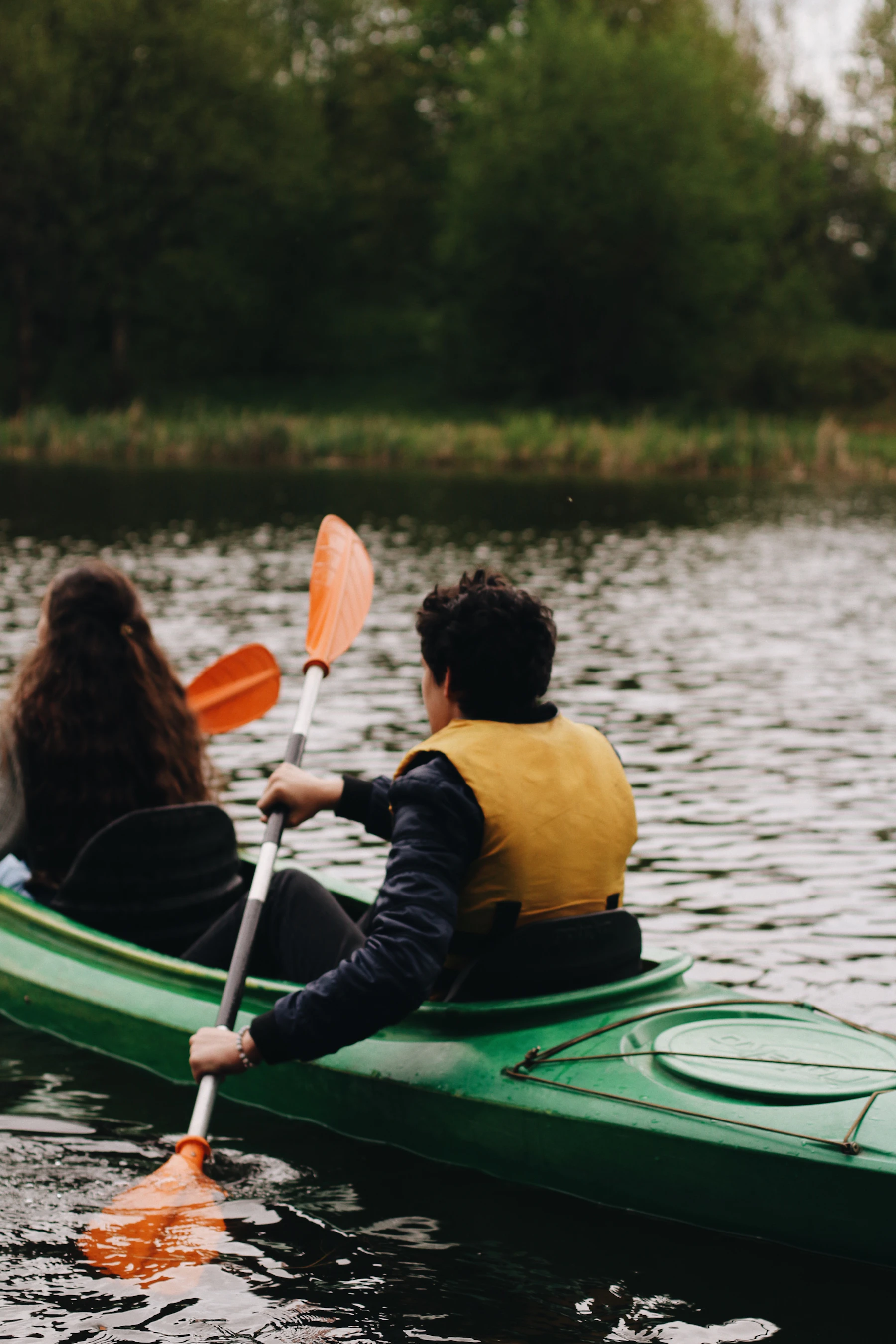 Outdoor kayaking gear and paddle movement on lake water