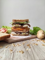 A freshly made sandwich stacked high with ingredients, ready to be served.