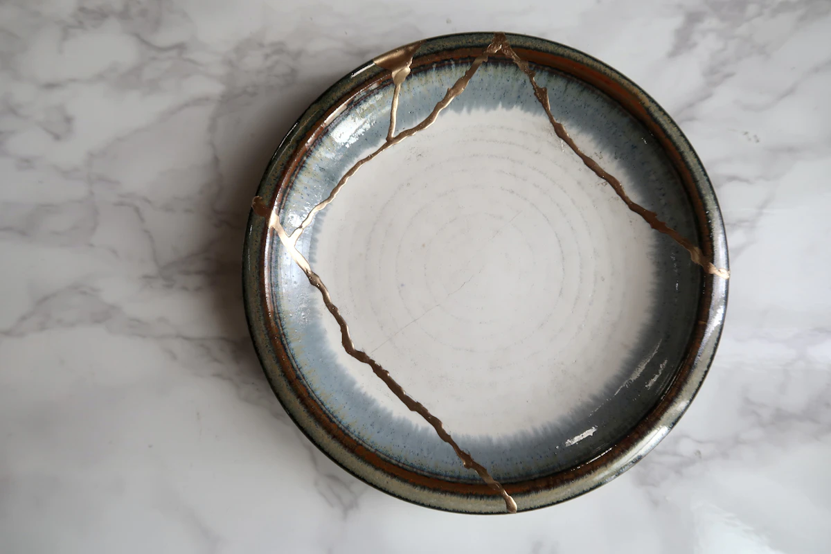A white and brown ceramic plate joined by gold-colored seams