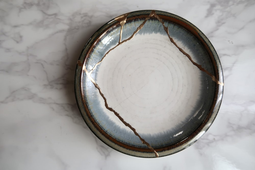 round brown and white ceramic plate kintsugi