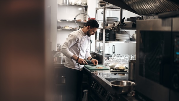 Close-up of a chef carefully preparing fresh ingredients in a professional kitchen environment.