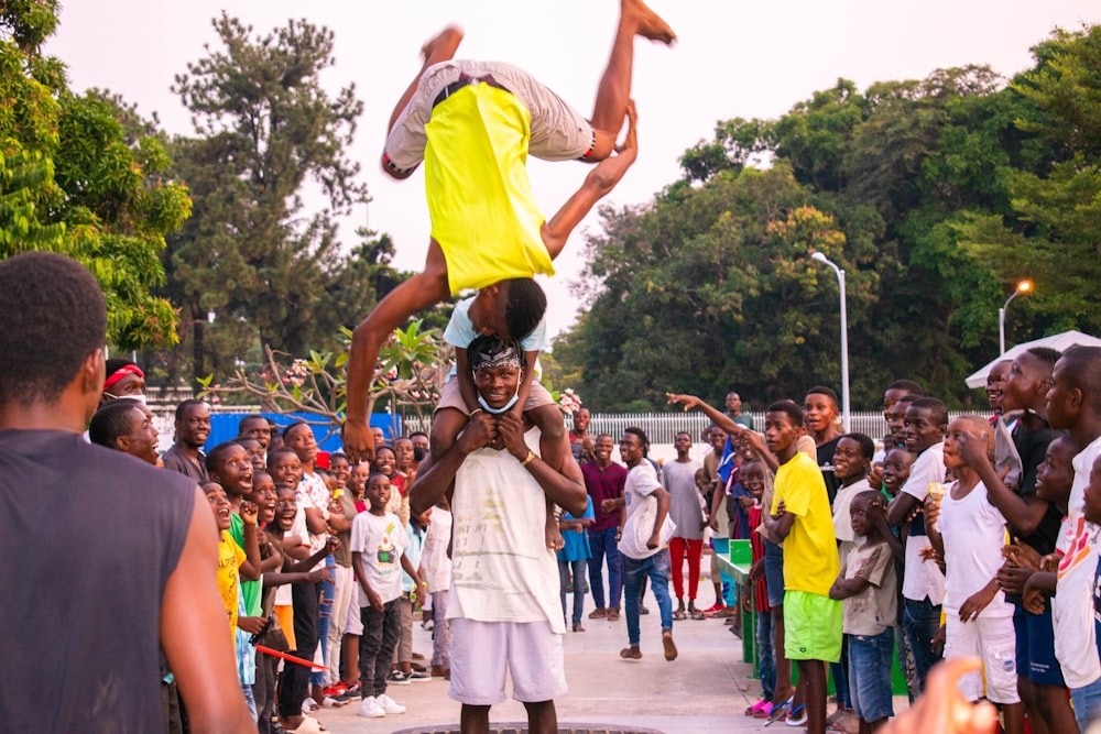 people in yellow shirt and white shorts dancing on street during daytime