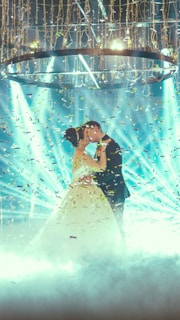 woman in white wedding dress holding blue string lights