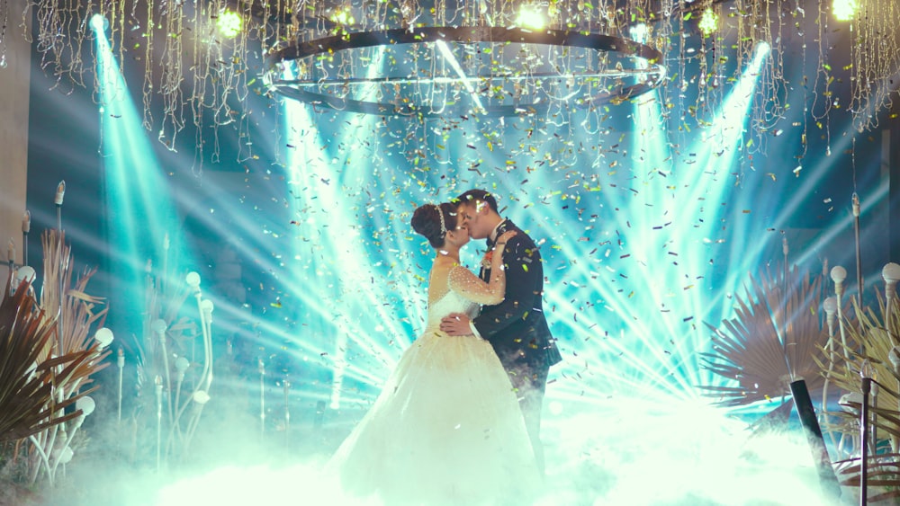 man and woman kissing under blue lights