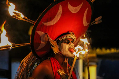 man in red and gold costume holding a stick