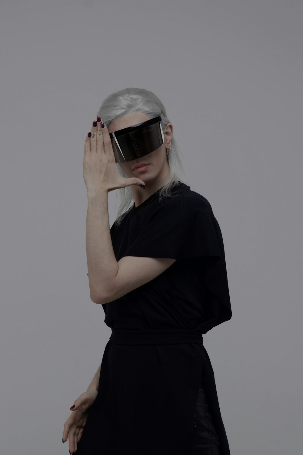 woman in black shirt covering her face with her hands