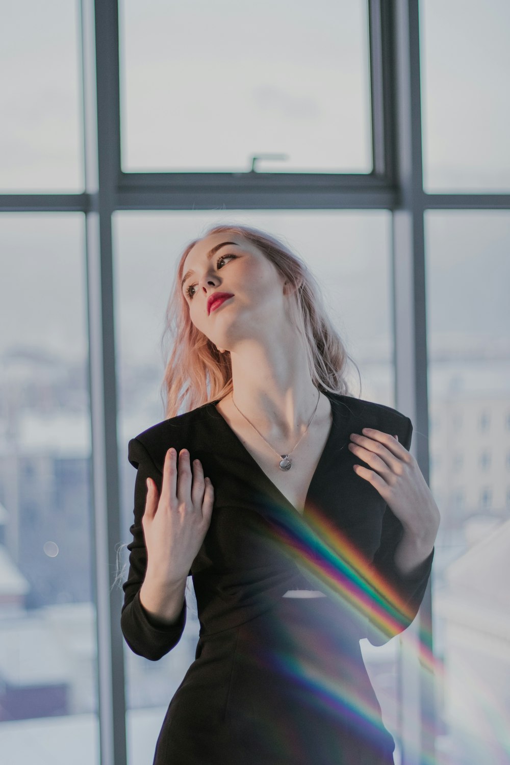 woman in black blazer standing near glass window