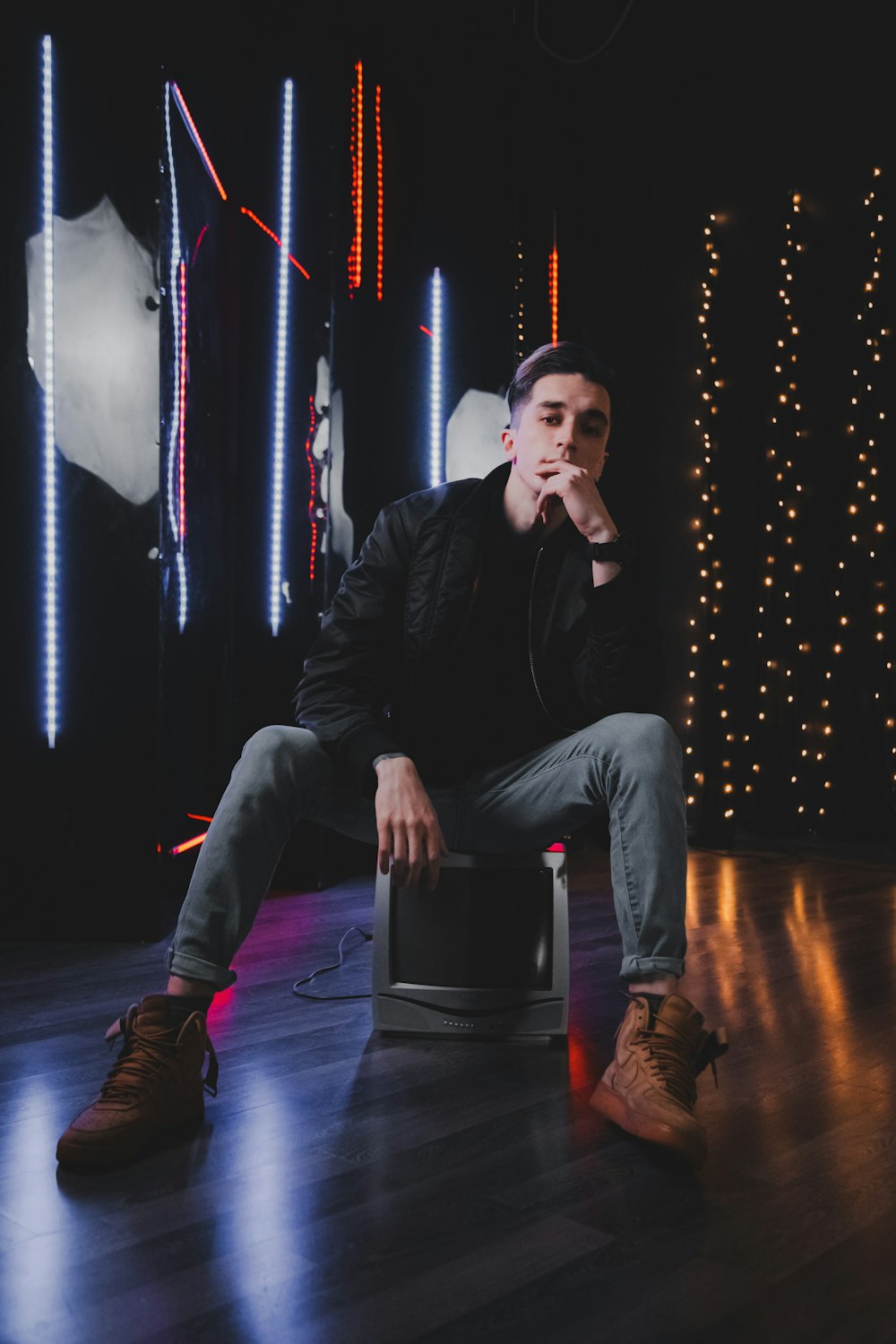 man in black leather jacket sitting on black chair