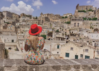 woman in red hat standing on gray concrete pavement during daytime