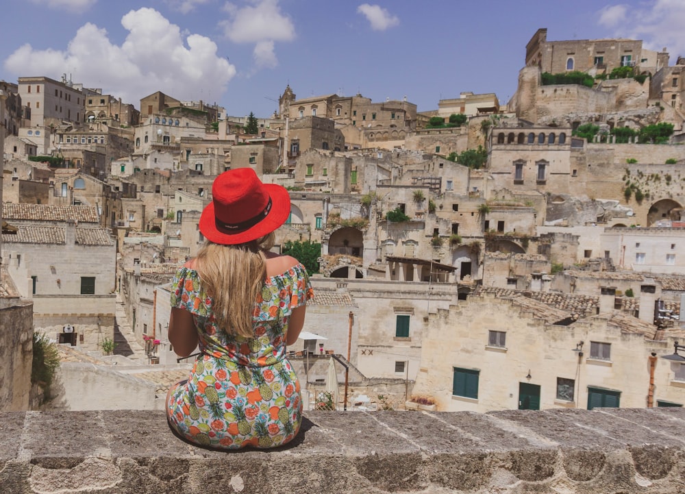 woman in red hat standing on gray concrete pavement during daytime