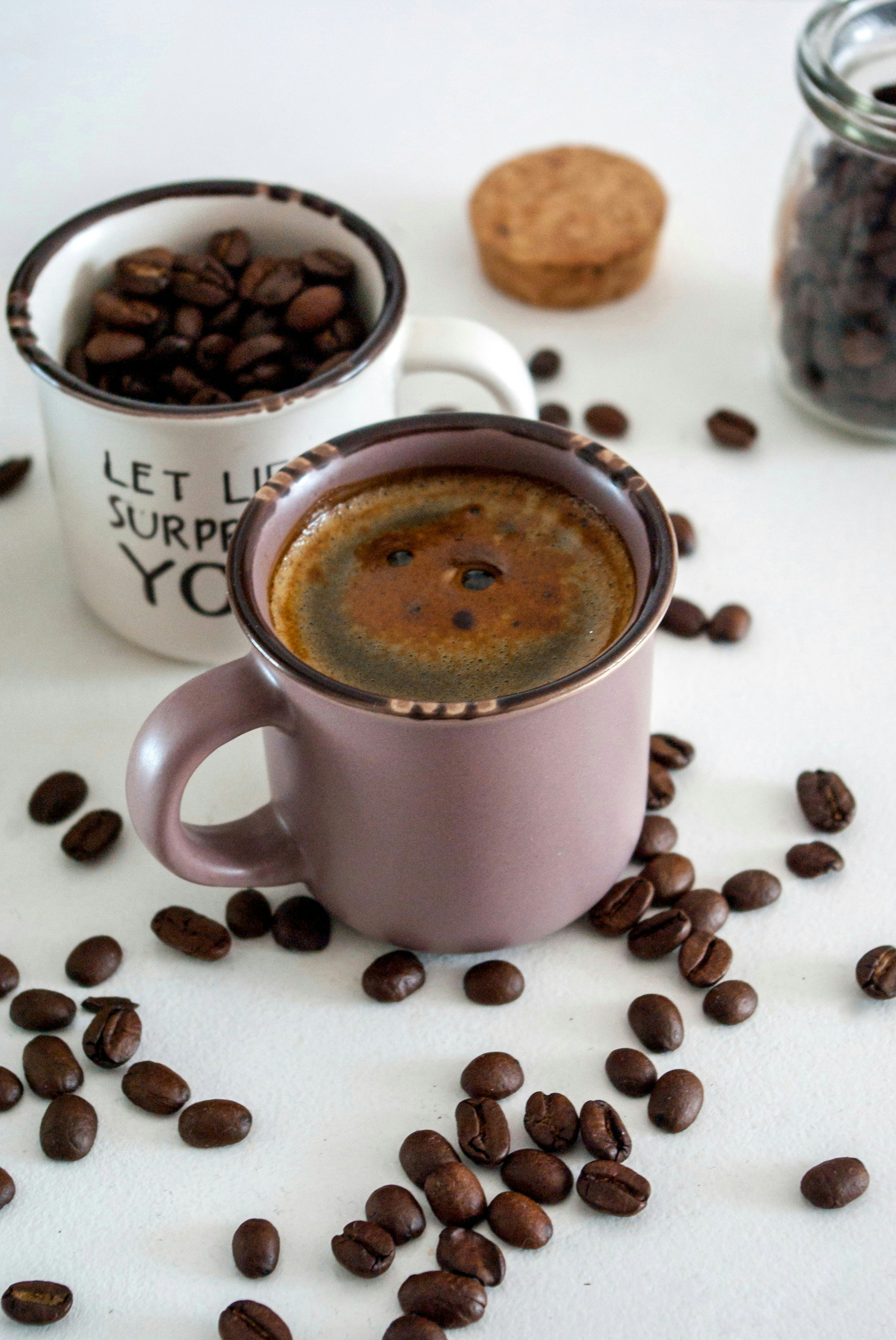 white ceramic mug with coffee beans