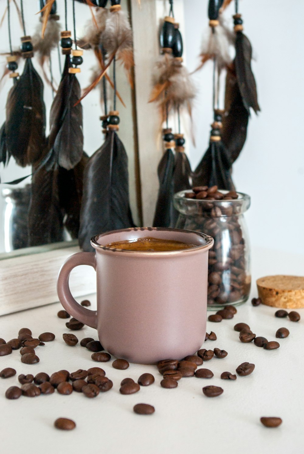 white ceramic mug with coffee beans on brown wooden table