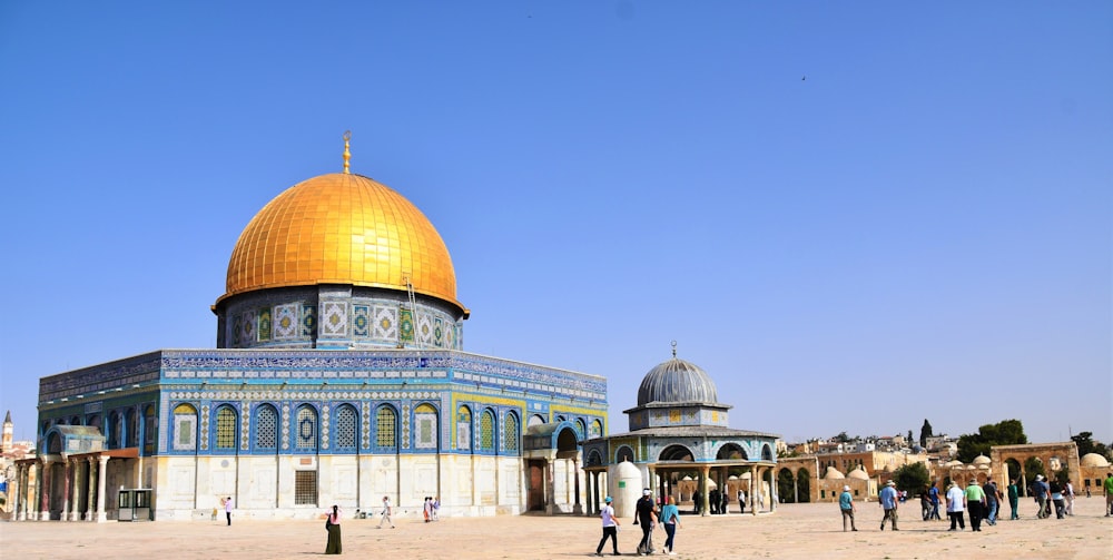 people walking on green and brown dome building under blue sky during daytime