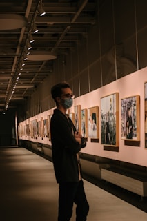 man in black suit standing near paintings