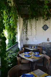 A cozy outdoor seating area in a lush garden with elegant tables set for a meal.