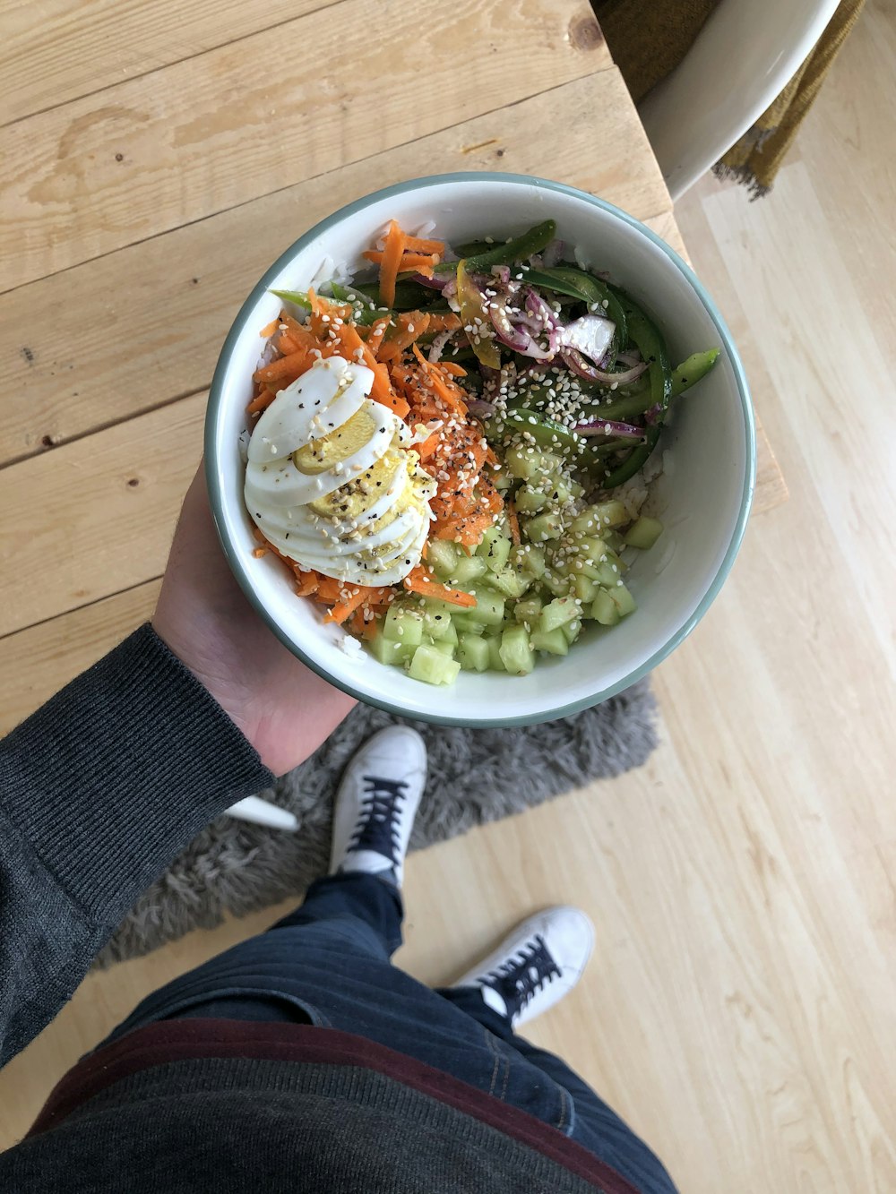 person holding white ceramic bowl with vegetable salad