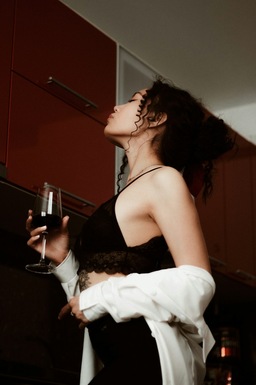 woman in black spaghetti strap top holding wine glass