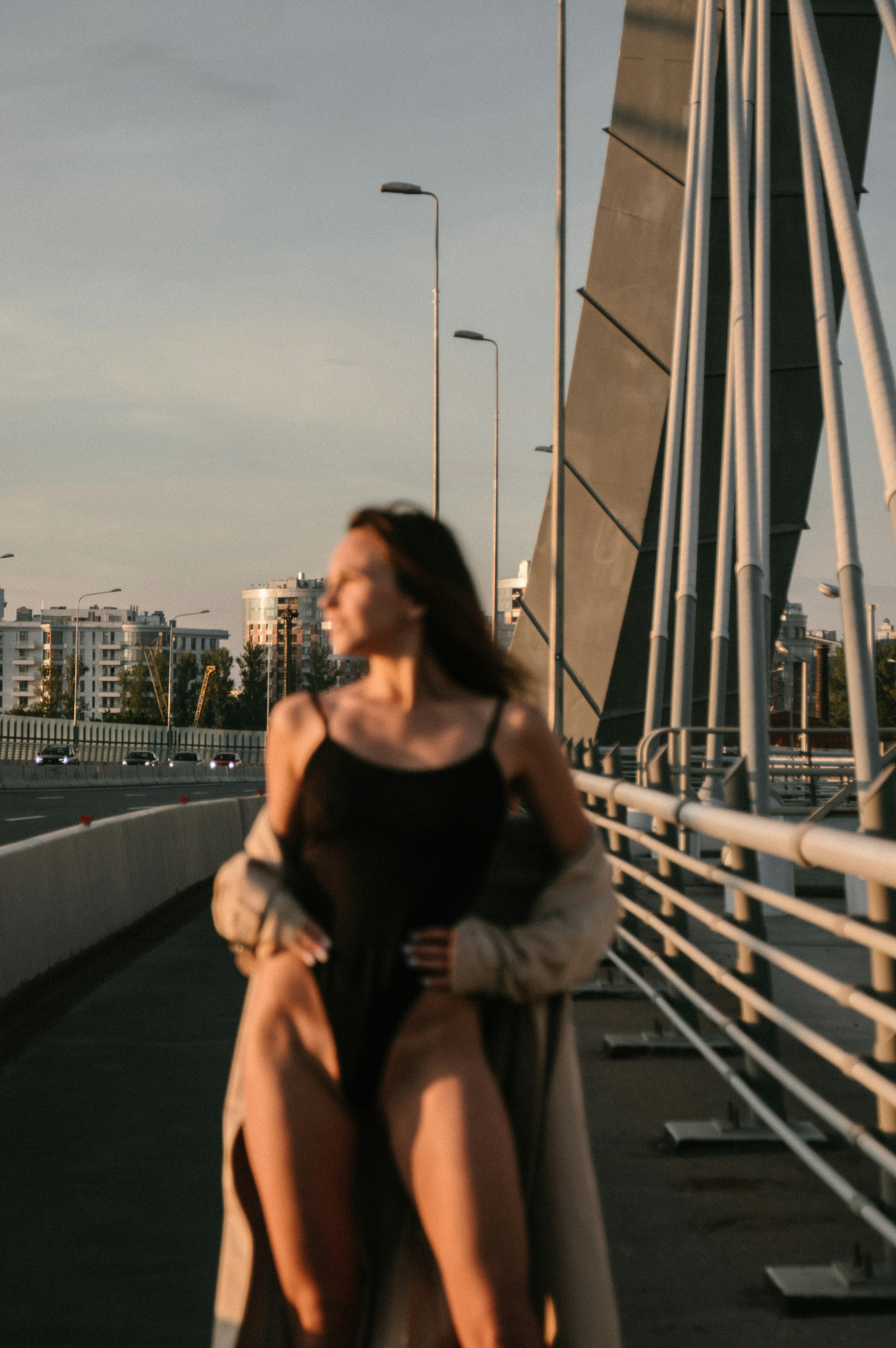 woman in black tank top and brown shorts standing on bridge during daytime