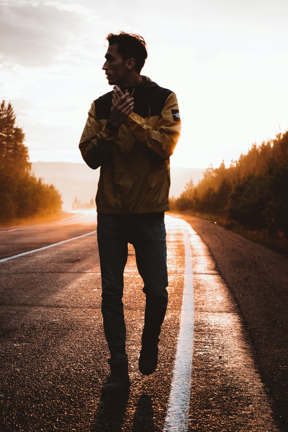 man in brown jacket standing on road during daytime